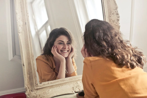 A woman looking at herself in the mirror